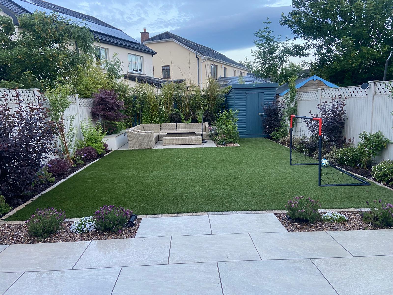 Completed artificial grass garden with planting, patio and football goal